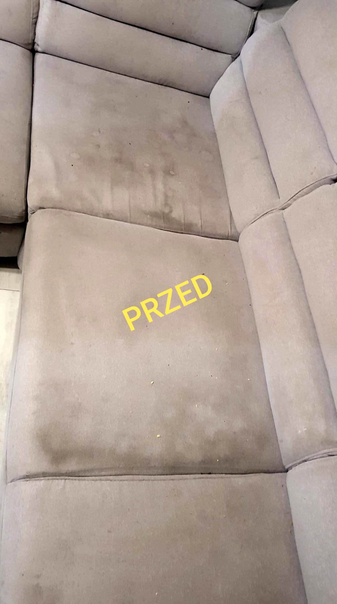Beżowa, narożna kanapa z widocznymi plamami i zabrudzeniami na siedzisku, z żółtym napisem 'PRZED' nałożonym na zdjęcie.