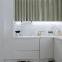 Nowoczesna kuchnia w odcieniach bieli z marmurowym blatem i złotą armaturą, widok na salon z elementami dekoracyjnymi w tle.