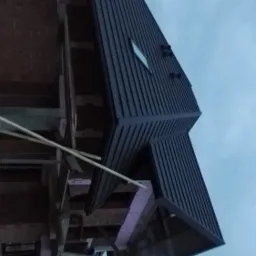 Nowoczesny dom w Jabłonce w trakcie budowy, z zamontowaną ciemną blachą trapezową na dachu i widoczną konstrukcją szkieletową.