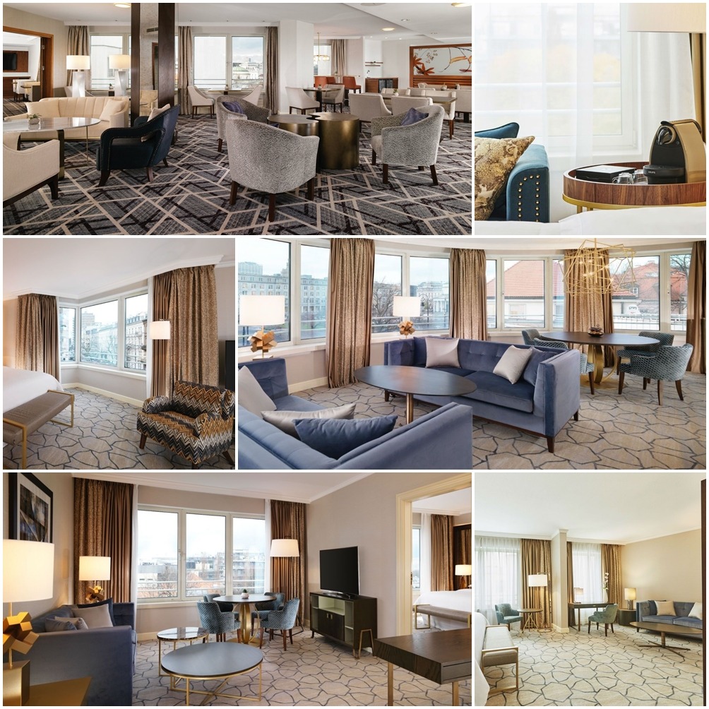 Wnętrze luksusowego apartamentu hotelowego z różnymi aranżacjami mebli tapicerowanych w odcieniach szarości i błękitu, z widokiem na miasto przez duże okna.