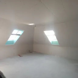 Poddasze z oknami dachowymi, ściany i sufit wykończone płytami kartonowo-gipsowymi przed szpachlowaniem, widoczne łączenia płyt.