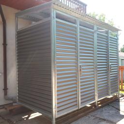 WELDER-SERWIS OLGA SIWIK - Metalowa konstrukcja osłaniająca śmietnik z falistej blachy, z widocznymi drzwiami i ramą, na zewnątrz budynku.