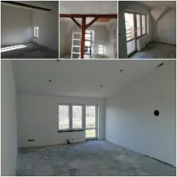 Wnętrze pokoju po malowaniu ścian na biało, widoczne gładzie, surowa podłoga i niezamaskowane otwory elektryczne, w tle okno z widokiem na drzewa.