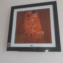 Klimatyzator LG Art Cool Gallery z wyświetlanym obrazem 'Pocałunek' Gustava Klimta, wiszący na białej ścianie.