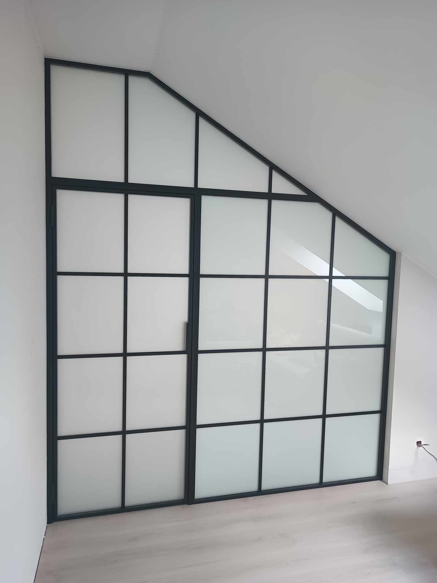 Nowoczesne dwuskrzydłowe drzwi wewnętrzne w stylu loftowym z czarnymi szprosami i mlecznym szkłem, dopasowane do skosu dachu, realizacja w Kartuzach.