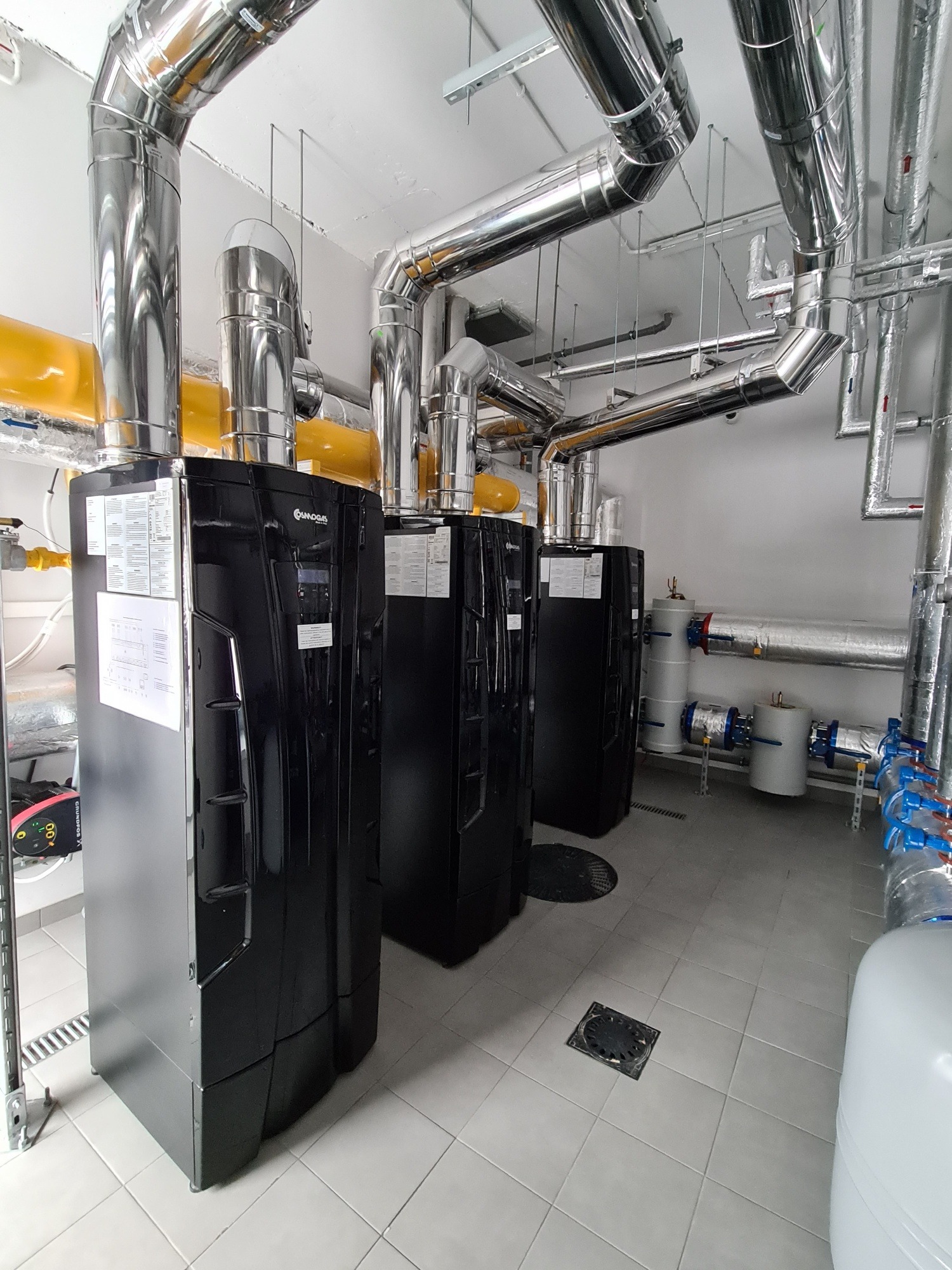 Kompleksowa instalacja kotłów grzewczych Osmogas z rurami i systemem odprowadzania spalin w kotłowni we Wrocławiu. Profesjonalny montaż.