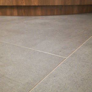 Szara, betonowa podłoga z widocznymi fugami w mieszkaniu w Myślenicach. Minimalistyczny design.