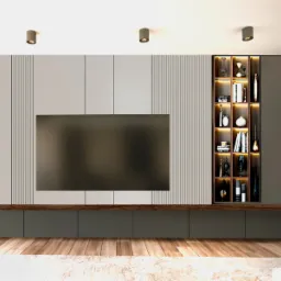 Salon z szarą ścianą telewizyjną, panelami dekoracyjnymi, drewnianą półką i podświetlaną półką na dekoracje, widok na fragment stolika kawowego i dywan