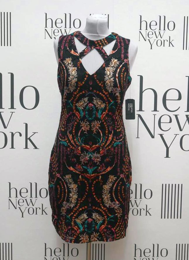 Czarna sukienka mini z dekoracyjnym, kolorowym wzorem paisley i wycięciami na dekolcie, prezentowana na manekinie na tle z napisem 'hello New York'.