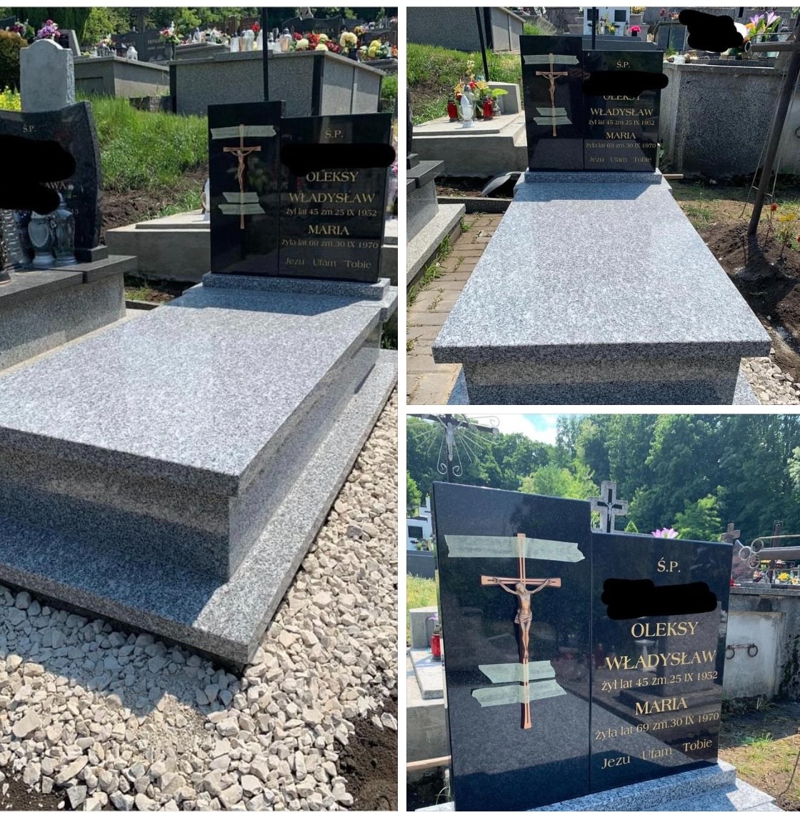 Granitowy nagrobek z czarną tablicą, krzyżem i inskrypcjami na cmentarzu w słoneczny dzień, otoczony kamieniami i zielenią.