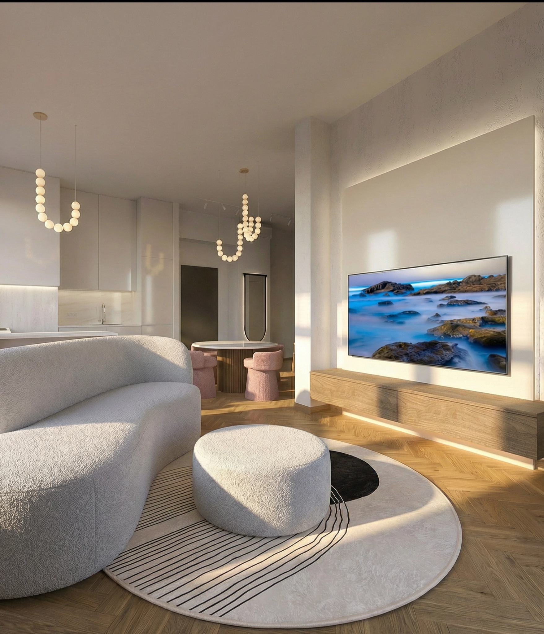 Jasne wnętrze z sofą boucle, okrągłym pufem na wzorzystym dywanie i telewizorem z podświetleniem LED. W tle widoczna kuchnia i jadalnia z okrągłym stołem.
