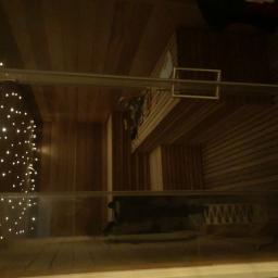 Cezary Pępczyński - Drewniana sauna z oświetleniem punktowym, widok z góry na wnętrze z ławkami i elementami konstrukcyjnymi.