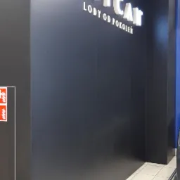 Okładzina HPL w kolorze antracytowym z podświetlanym napisem 'Grycan Lody od Pokoleń' w Pasażu Grunwaldzkim we Wrocławiu, widoczny fragment podłogi z płytek.