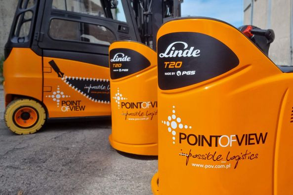 Pomarańczowe wózki widłowe Linde T20 z logo Point of View, prezentujące usługi magazynowania i transportu. Widoczne detale brandingowe.