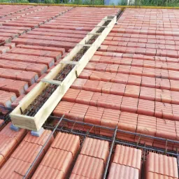 Wieniec stropowy w szalunku drewnianym, zbrojony stalą, ułożony na pustakach ceramicznych stropowych.