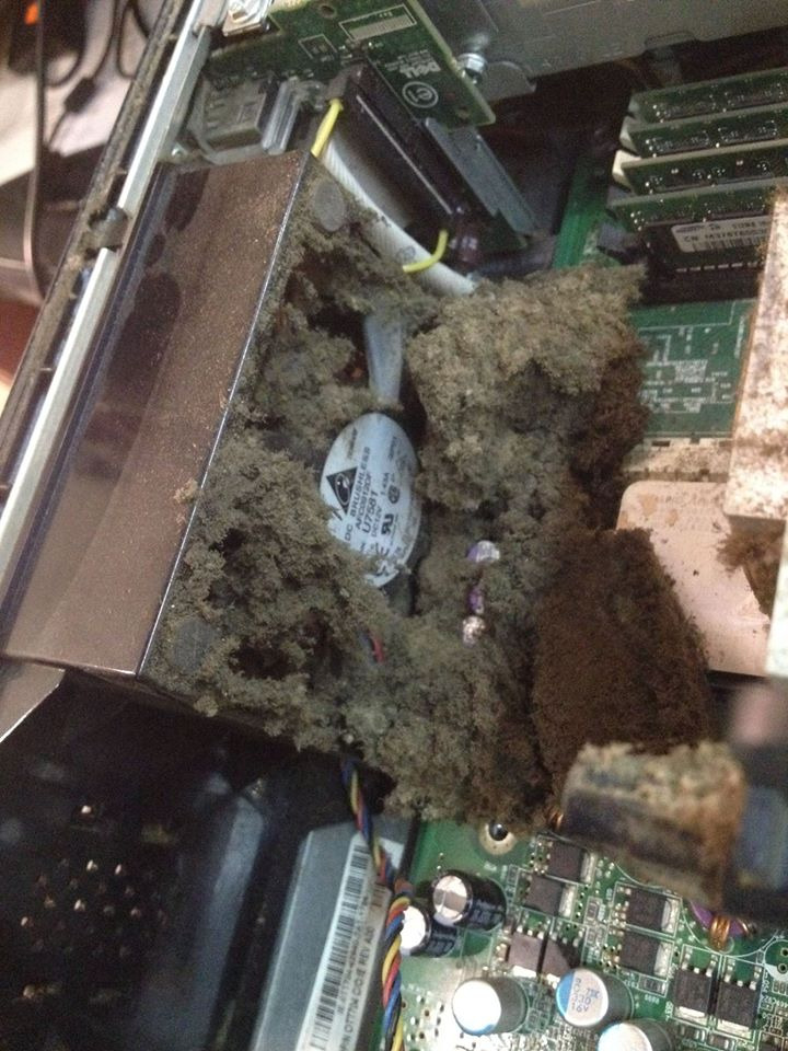 Wnętrze komputera stacjonarnego, całkowicie zatkane grubą warstwą szarego kurzu, uniemożliwiającą pracę wentylatora i zasłaniającą komponenty płyty głównej.