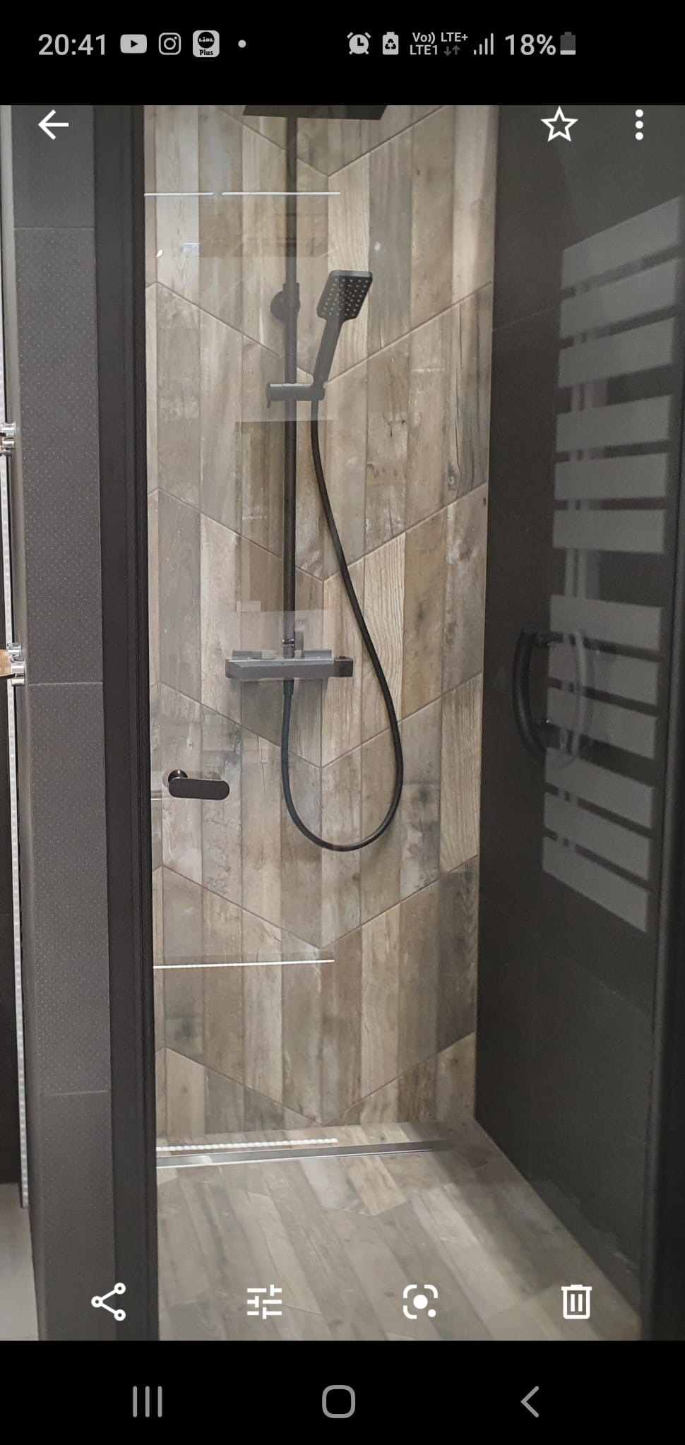 Kabina prysznicowa z deszczownicą i półką w Będzinie, wykończona płytkami imitującymi drewno ułożonymi w jodełkę.