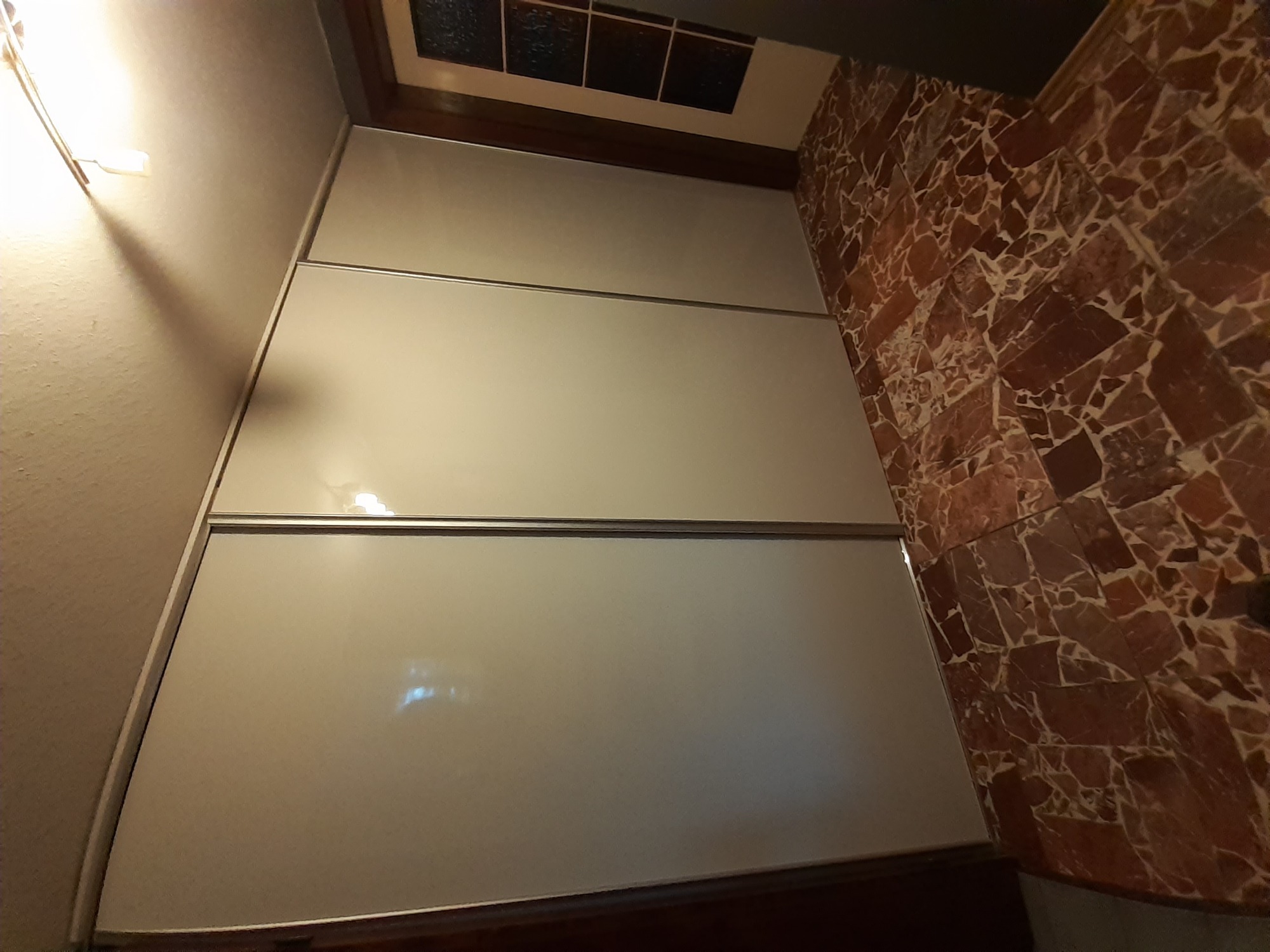 Ściana z płyt kartonowo-gipsowych w trakcie prac wykończeniowych w Pile, widoczna także ściana wyłożona mozaiką z kamienia.