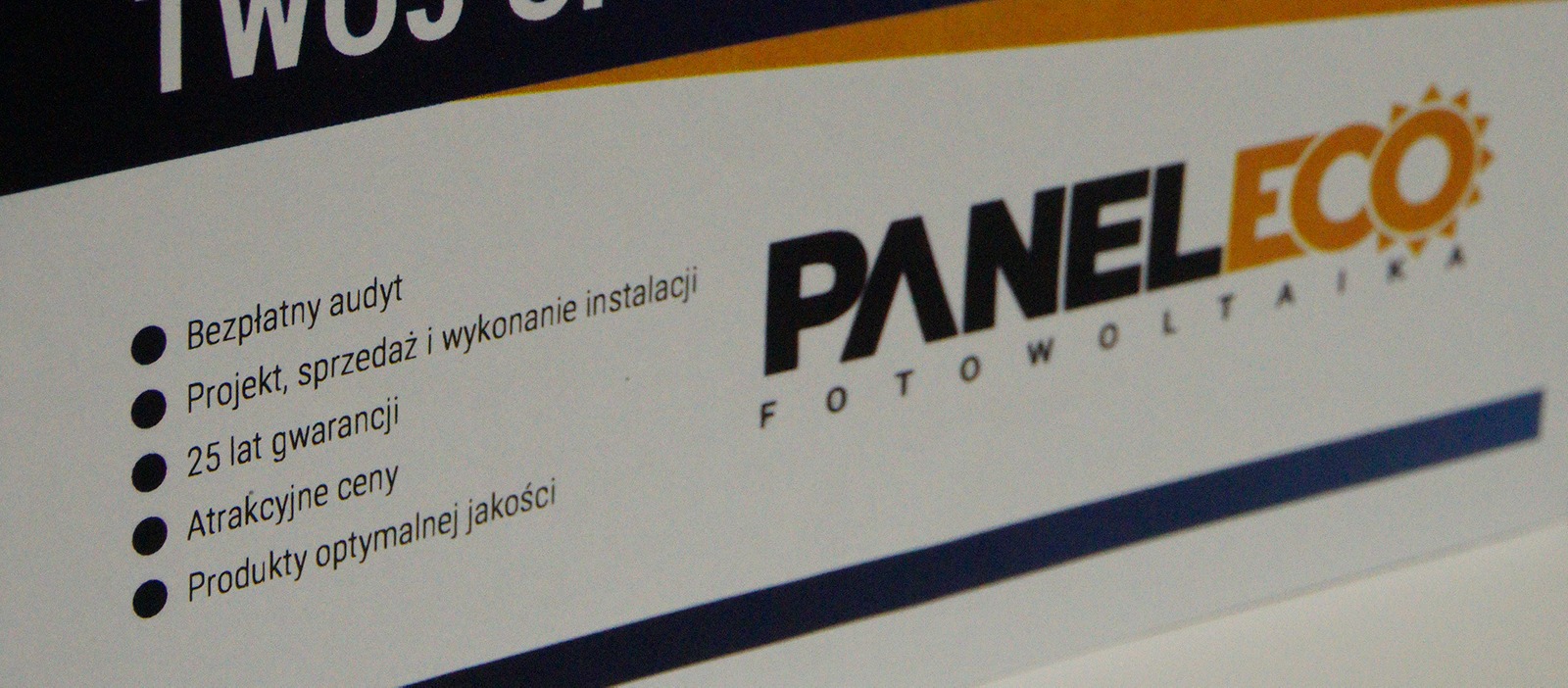 Ujęcie z bliska ulotki reklamowej firmy PanelEco Fotowoltaika, oferującej bezpłatny audyt, projekt, sprzedaż i wykonanie instalacji, 25 lat gwarancji oraz atrakcyjne ceny.