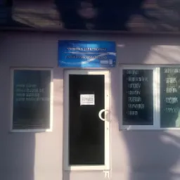 Fasada budynku z szyldem 'Naprawa Elektroniki / Usługi Informatyczne', z informacjami o naprawie komputerów, laptopów, tabletów, telefonów i telewizorów oraz skupie uszkodzonych urządzeń.