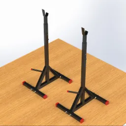 Dwie czarne, regulowane stojaki na sztangę z czerwonymi elementami na drewnianej powierzchni, widoczne śruby regulacyjne.