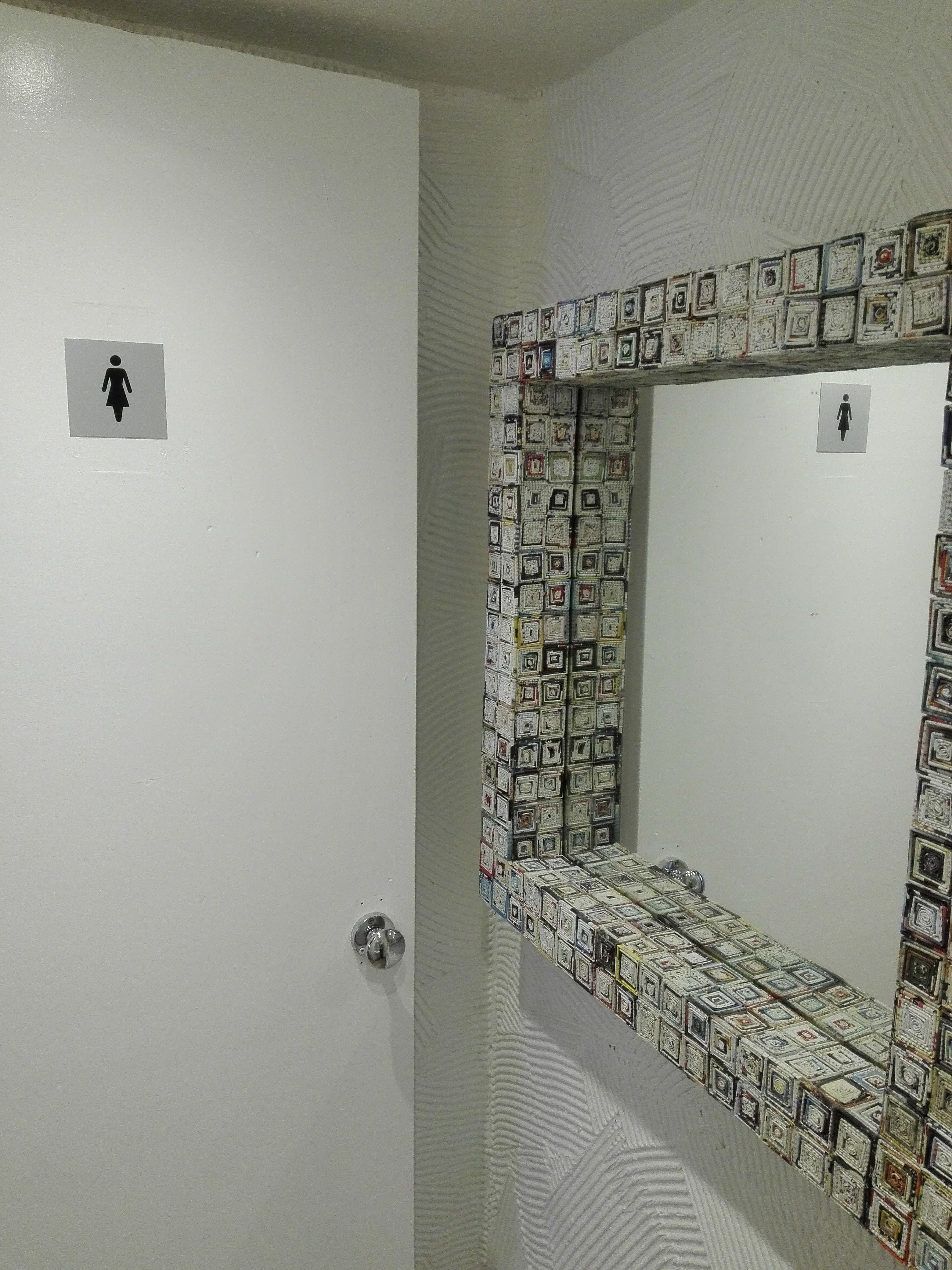 Toaleta dla kobiet z lustrem w ramie z recyklingu, ściana z dekoracyjnym tynkiem.