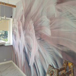 Usługi ogólnobudowlane Jacek Michorzewski - Pokój po tapetowaniu z motywem piór, widoczna drabina malarska i nowoczesna lampa wisząca.