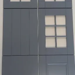 Szare, drewniane fronty meblowe o różnych wzorach: z ramkami i podziałami na sześć pól, gładkie, z pionowymi wgłębieniami oraz z prostokątną ramką.