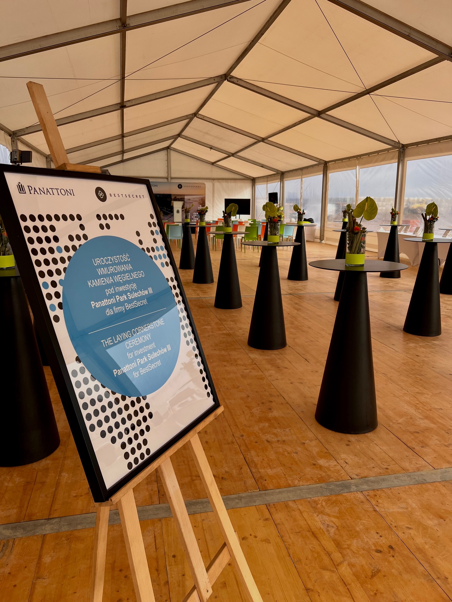 Uroczystość wmurowania kamienia węgielnego pod inwestycję Panattoni Park Sulechów III dla firmy BestSecret, widok na salę z wysokimi stolikami i dekoracjami kwiatowymi.