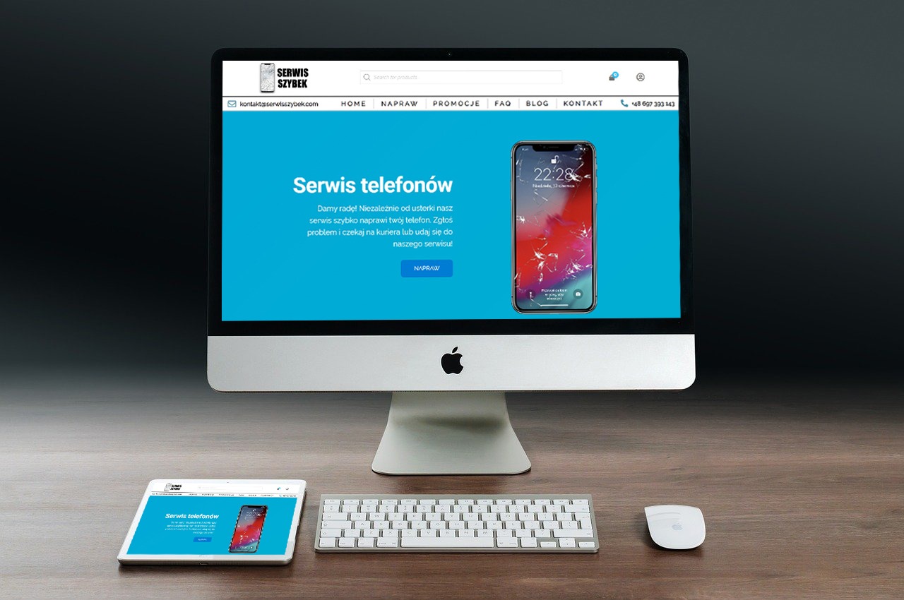 Prezentacja responsywnej strony internetowej serwisu naprawy telefonów na iMacu i tablecie, ukazująca uszkodzony ekran smartfona. Minimalistyczna biała klawiatura i mysz na drewnianym biurku.