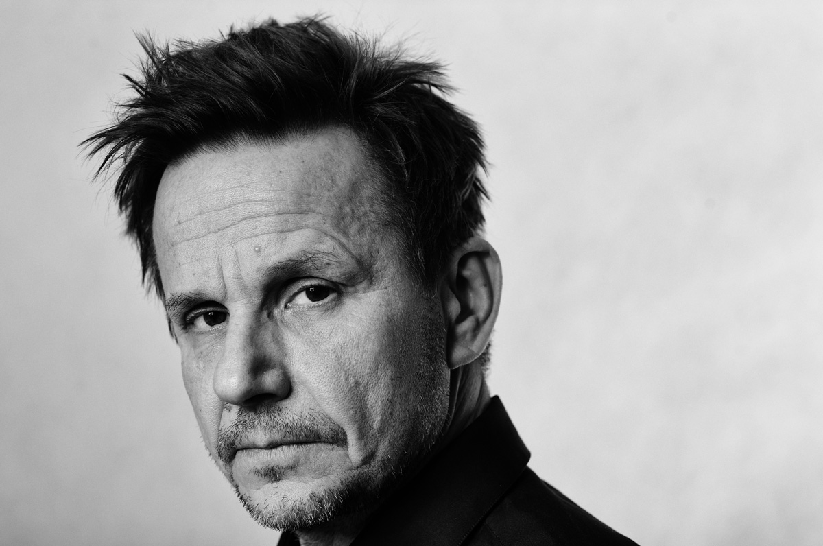 Czarno-biały portret mężczyzny z krótką brodą i zmierzwionymi włosami, skierowany lekko w bok, z wyrazem powagi.