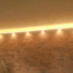 Remont pokoju widok z przodu ściany z imitacja cegły wraz z podwójnym oświetleniem w zabudowiez płyty G-k CZ3.