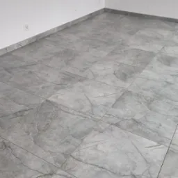 Szare, marmurkowe płytki podłogowe ułożone w pustym pomieszczeniu z białymi ścianami i gniazdkami elektrycznymi przy podłodze. Widok z góry, neutralne oświetlenie.