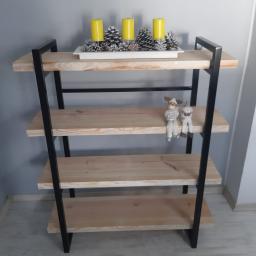 Montex - Ręcznie robiony regał z jasnego drewna i czarnych metalowych elementów, na półkach dekoracje: żółte świece, srebrne szyszki i figurki renifera i bałwanka.