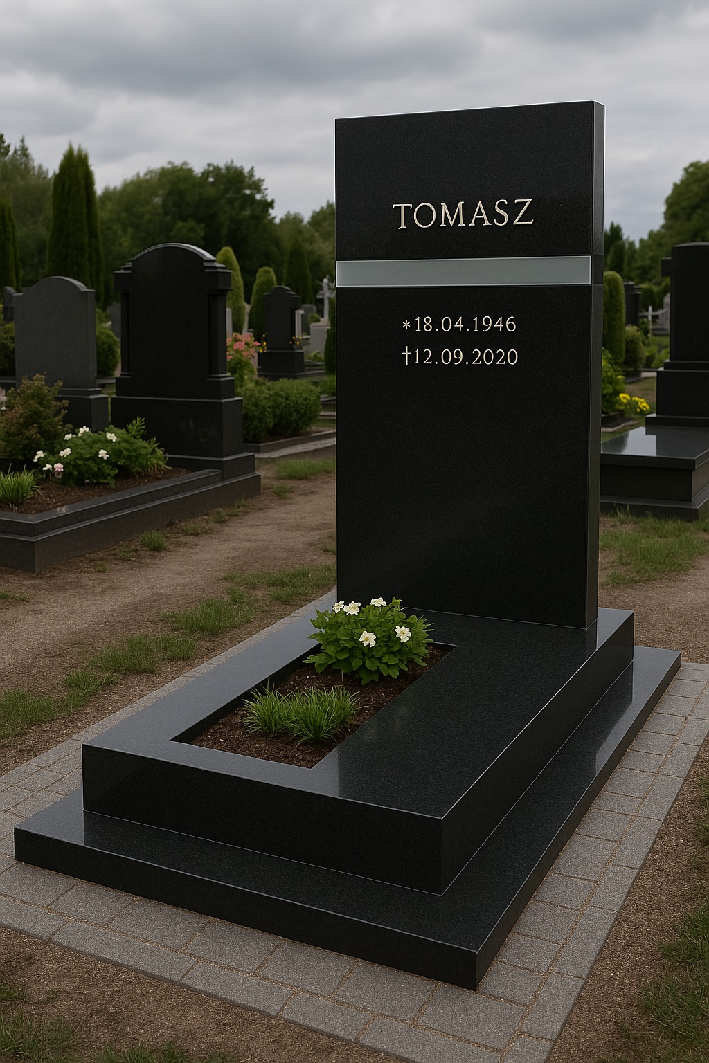 Czarny, nowoczesny nagrobek z miejscem na kwiaty, na cmentarzu, z inskrypcją 'Tomasz', datą urodzenia i śmierci. Widok z przodu, pochmurne niebo w tle.