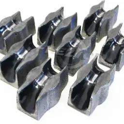 Rząd odlewanych, szarych, metalowych rolek z charakterystycznym wycięciem w kształcie litery U, ułożonych na białym tle.