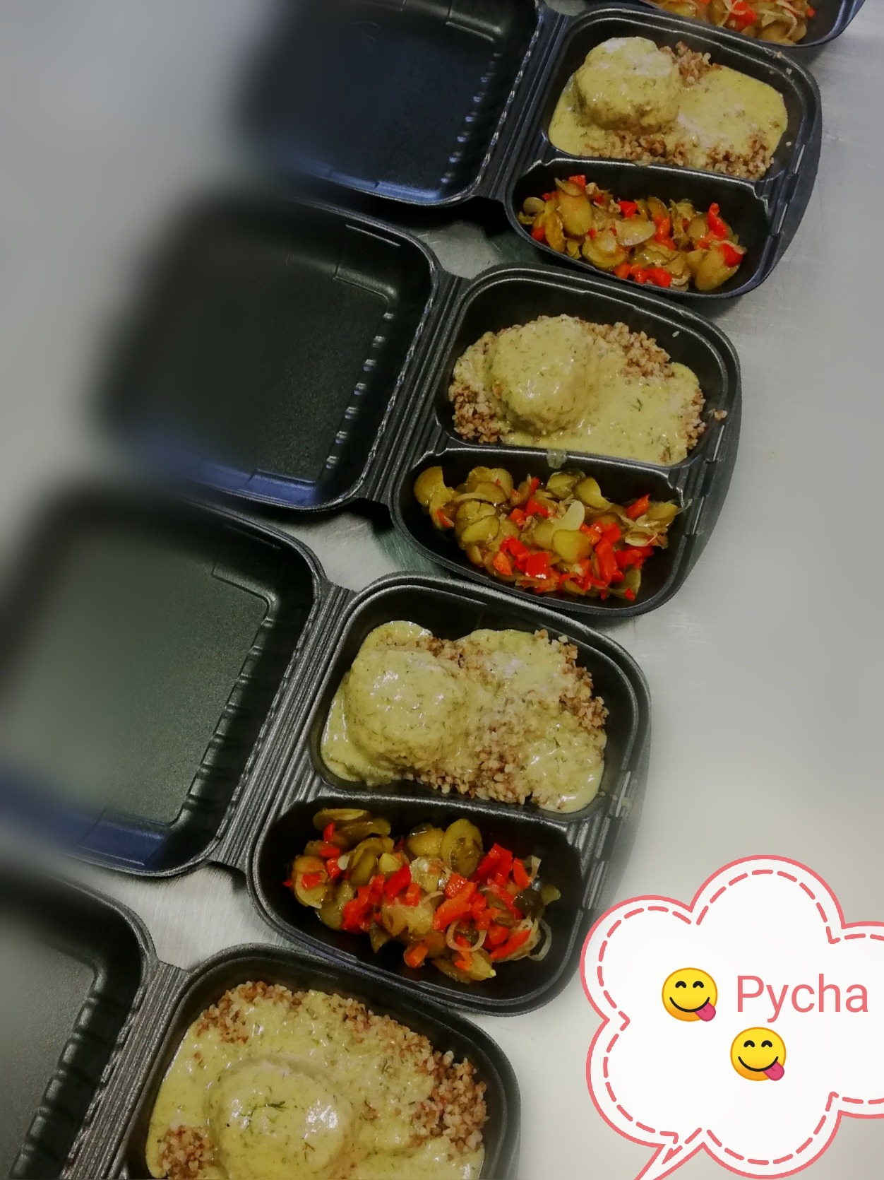 Zestaw obiadowy w czarnym, dzielonym pojemniku: kotlety w sosie koperkowym z kaszą gryczaną i warzywa duszone z czerwoną papryką.