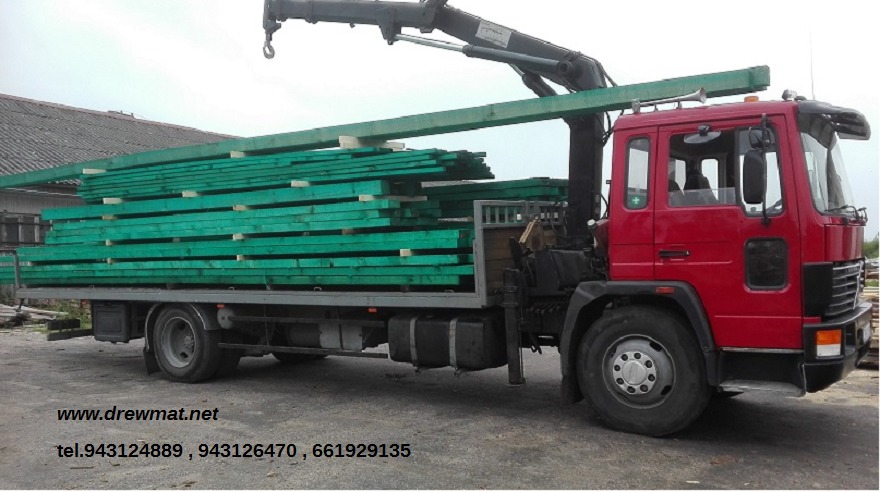 Ciężarówka z dźwigiem załadowana impregnowaną na zielono kantówką, widoczne numery telefonów i adres strony internetowej na dole zdjęcia.