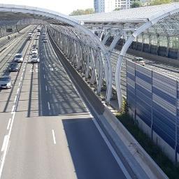 AS Piaseczno Odwodnienia liniowe. - Autostrada z ekranami akustycznymi i zadaszeniem w formie łukowych konstrukcji stalowych, widok z góry na ruch samochodowy.