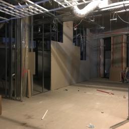 MGL Ochir-Erdene Tserensodnom - Wnętrze w trakcie montażu ścian działowych z płyt karton-gips, widoczne metalowe profile, częściowo zamontowane płyty, instalacje pod sufitem oraz kartony na podłodze.