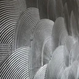 Dekoracyjna ściana z szarego tynku strukturalnego, wzór półokręgów z wyraźnymi żłobieniami, widok z boku.