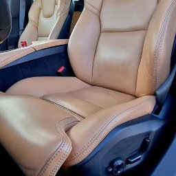 2KB AUTO DETAILING - Beżowe skórzane fotele samochodowe z precyzyjnym szwem widoczne z bliska, wnętrze pojazdu w Nowym Tomyślu.