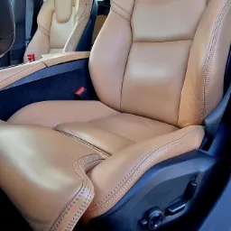 Beżowe skórzane fotele samochodowe z precyzyjnym szwem widoczne z bliska, wnętrze pojazdu w Nowym Tomyślu.