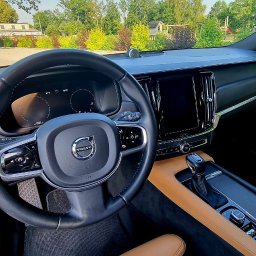 2KB AUTO DETAILING - Wnętrze luksusowego samochodu Volvo z beżową skórzaną tapicerką, widok na deskę rozdzielczą, kierownicę z logo Volvo i cyfrowy wyświetlacz.