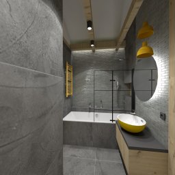 Venosfera Anna Dąbrowska - Wizualizacja nowoczesnej łazienki z szarymi płytkami imitującymi kamień, żółtymi akcentami w postaci grzejnika i umywalki, kabiną prysznicową typu walk-in oraz okrągłym lustrem z podświetleniem.