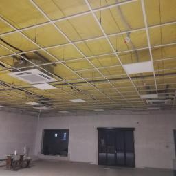 Instal-Tech Arkadiusz Miś - Sufit podwieszany w trakcie montażu w pomieszczeniu biurowym, widoczne instalacje, oświetlenie i jednostki klimatyzacyjne.