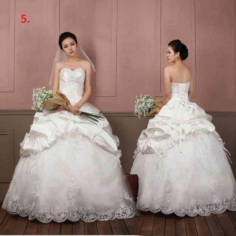 Dwie modelki prezentują suknie ślubne: jedna z przodu, trzymając bukiet, druga z tyłu, ukazując wiązanie gorsetowe i drapowania. Suknie posiadają gorsety zdobione koronką i tiulowe spódnice...