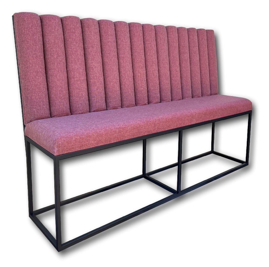 Długa ławka tapicerowana różową tkaniną z pionowymi przeszyciami na oparciu, osadzona na czarnej, metalowej ramie o geometrycznym kształcie.