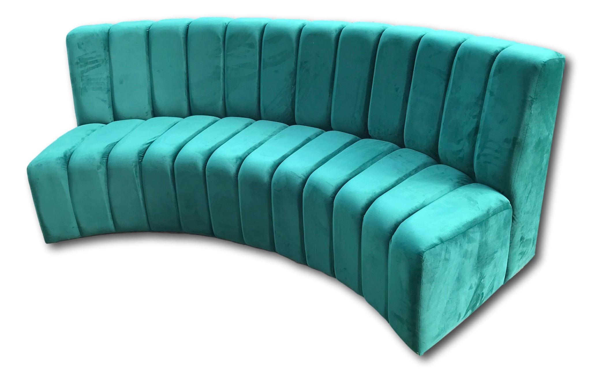 Turkusowa sofa z aksamitną tapicerką, o zakrzywionym kształcie i pionowych przeszyciach, na białym tle.