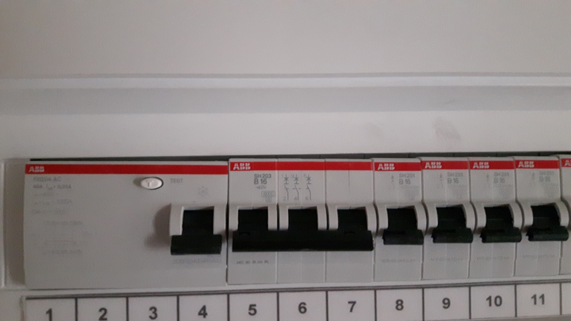 Rozdzielnica elektryczna z wyłącznikami nadprądowymi ABB, widoczne numery obwodów od 1 do 11.
